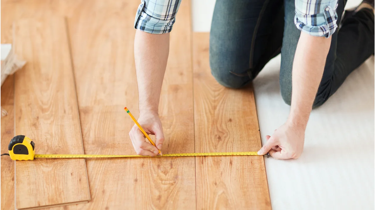 A person doing room measurements in linear feet values